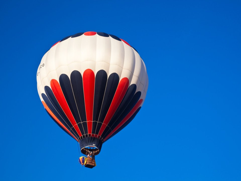 Colorful Hot Air Balloon Flying Under Clear Blue Sky