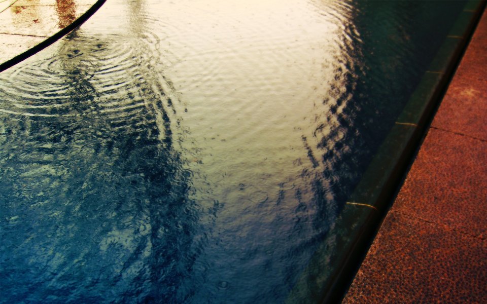 雨中游泳池的涟漪水面