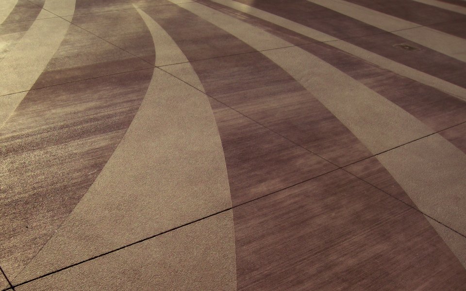 Warm Sunlight Arc Striped Cement Pavement Close Up