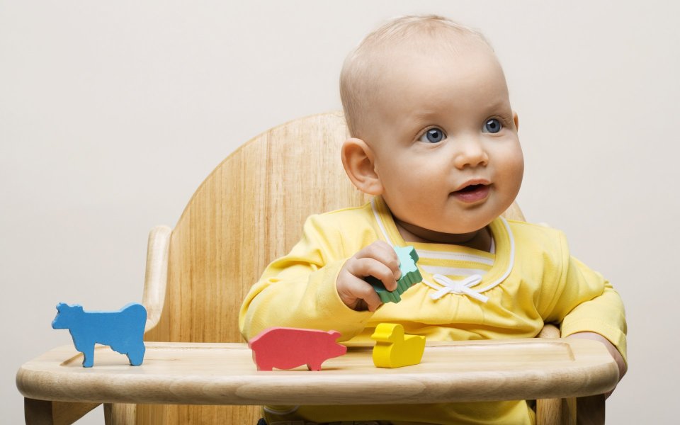 Cute Baby Playing Colorful Wooden Animal Blocks On High Chair