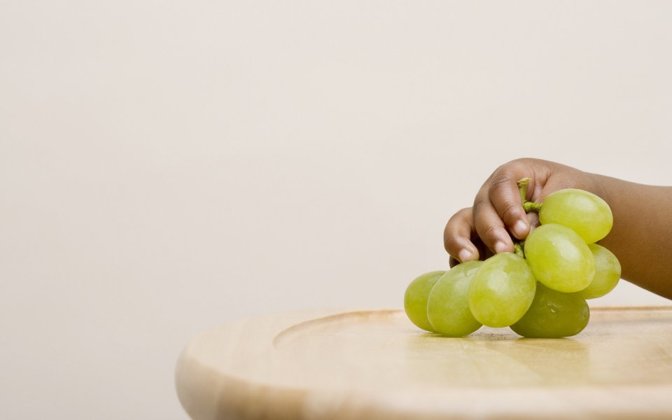 Toddler Hand Holding Fresh Green Grapes Closeup