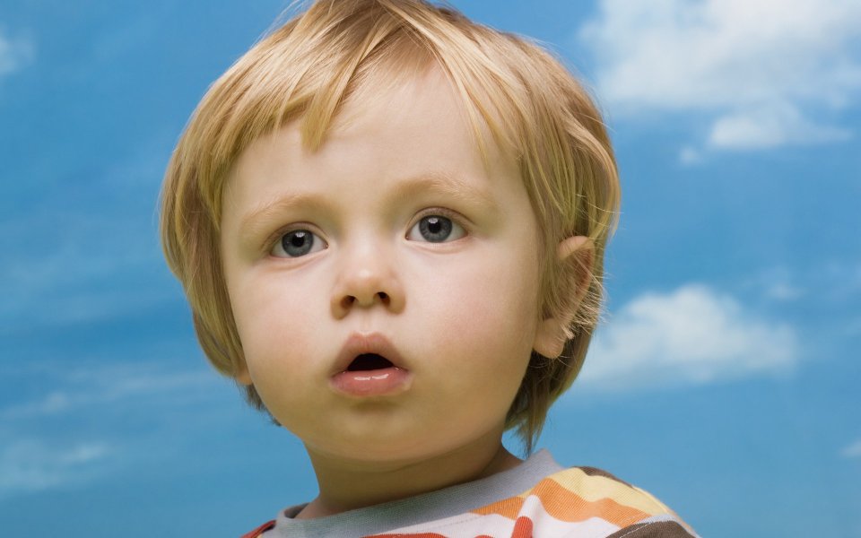 Blonde Blue Eyed Toddler Portrait Against Blue Sky White Clouds