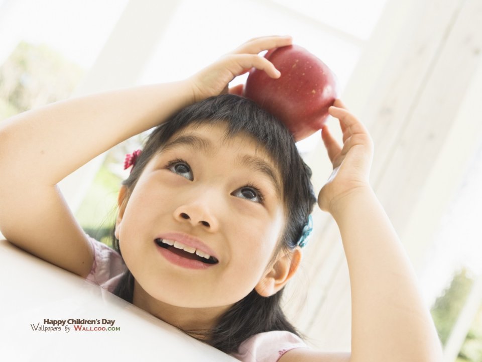Cute Asian Little Girl With Red Apple On Head Childrens Day Photo