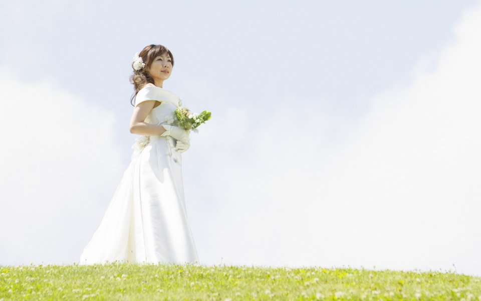 晴朗户外草坪上手持捧花的婚纱新娘 花园婚礼婚纱照