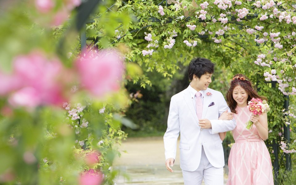 花园婚礼摄影 蔷薇花廊下漫步的新婚夫妇婚纱照