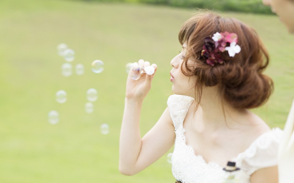 Bride Blowing Bubbles On Lawn Garden Wedding Photo