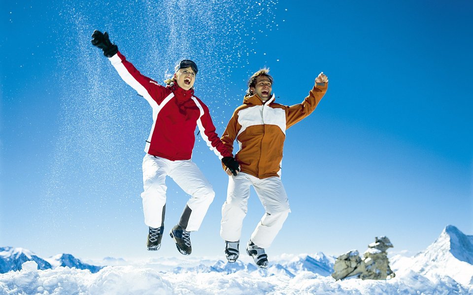Happy Couple Jumping In Snowy Mountains