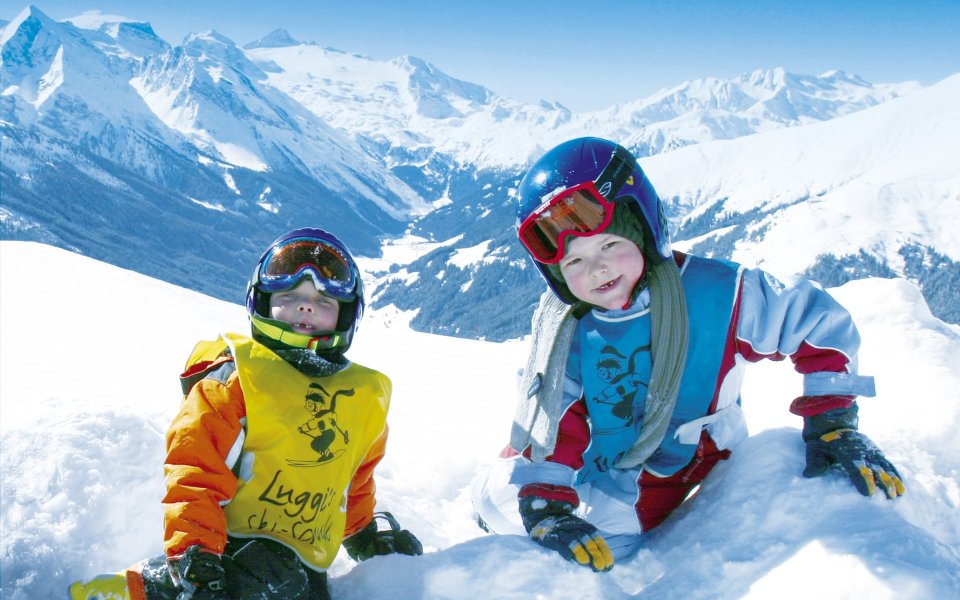 Happy Children Skiing In The Alps