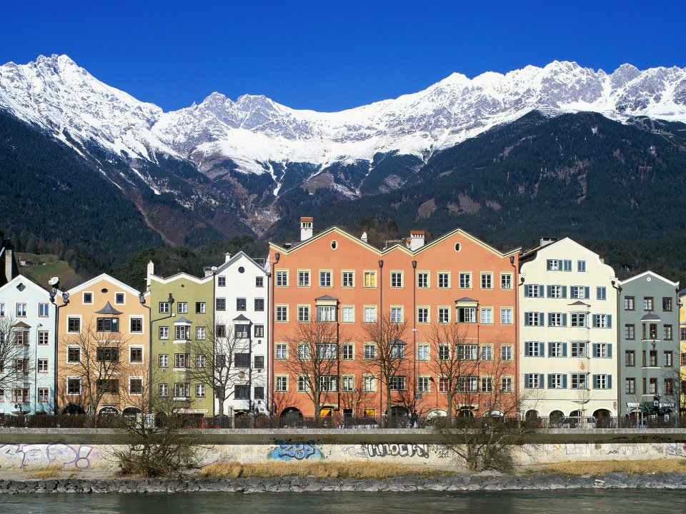 奥地利因斯布鲁克因河畔彩色建筑雪山风光