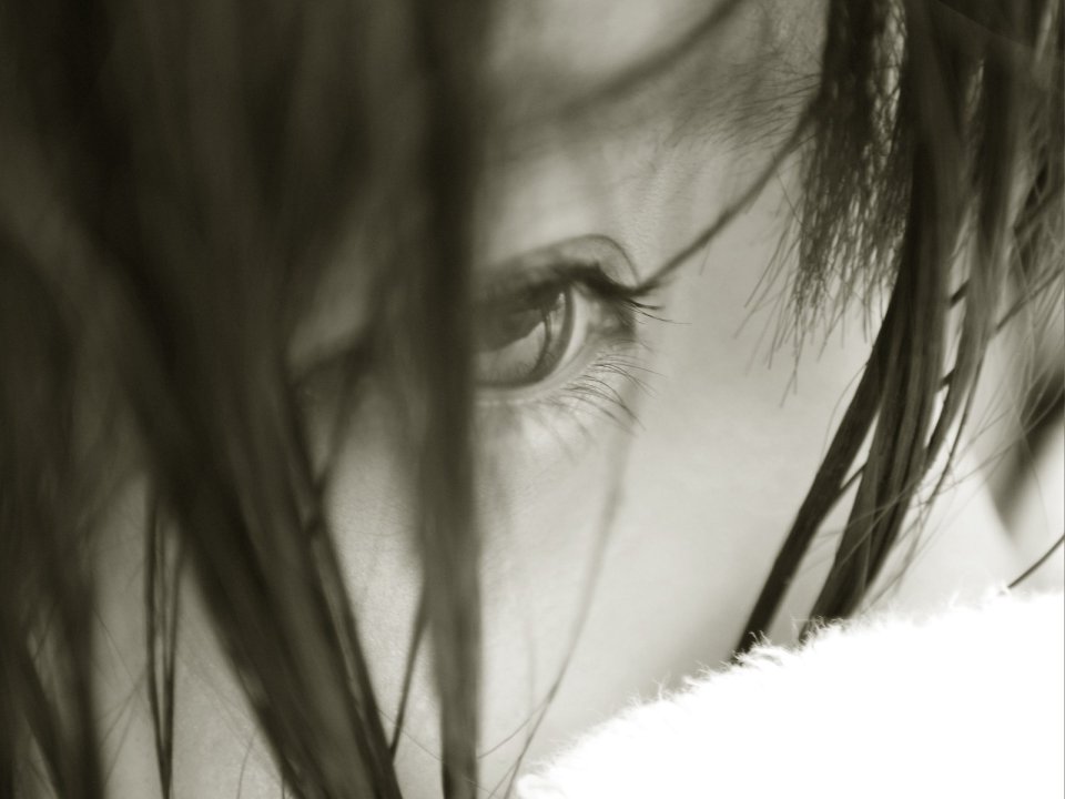 Black And White Closeup Of Womans Eye Partially Covered By Hair