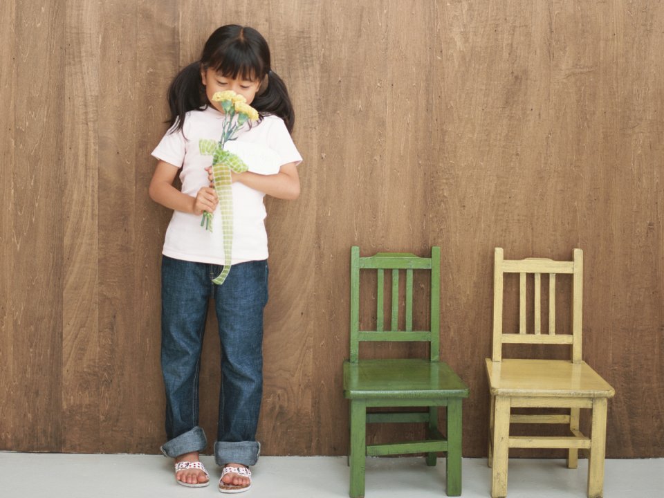 Little Girl Holding Carnation By Wooden Wall