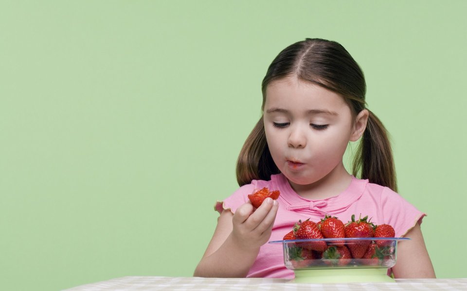 Little Girl With Pigtails Eating Fresh Strawberries