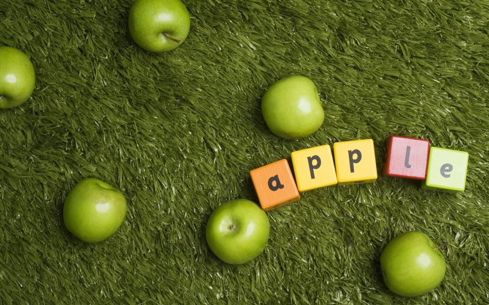 Green Apples And Letter Blocks Spelling Apple On Grass