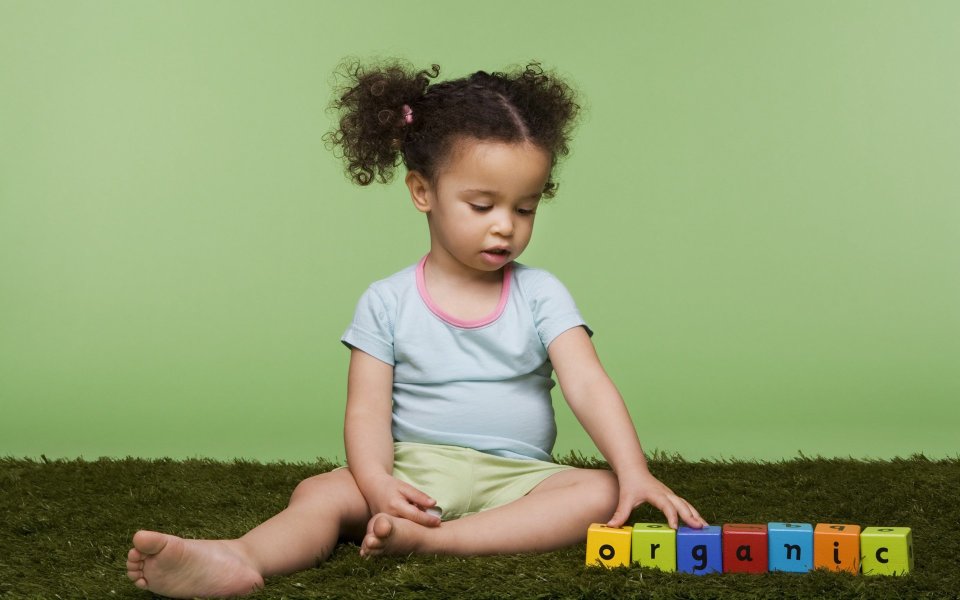 Little Girl Playing Colorful Alphabet Blocks On Simulated Grass