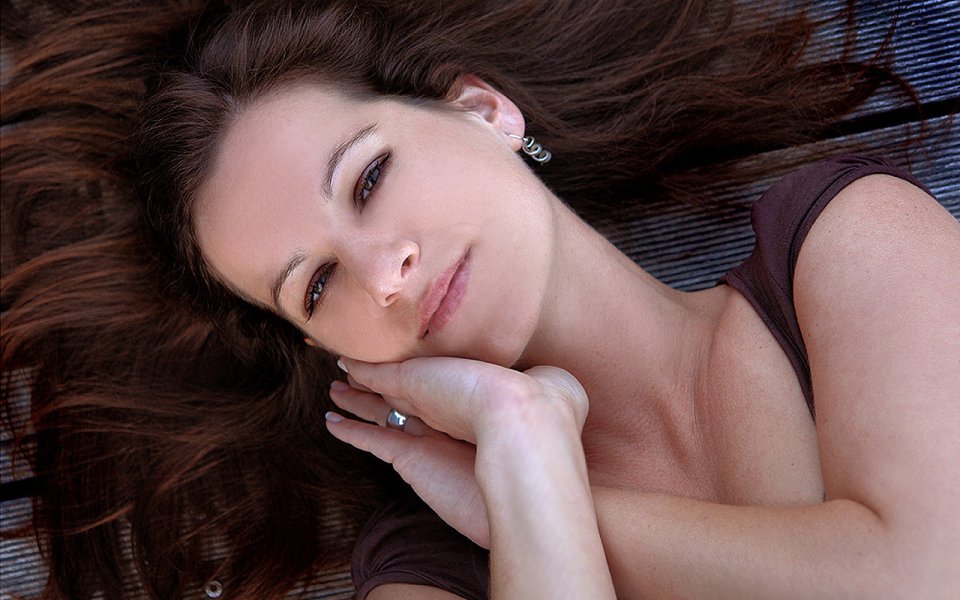 Gentle Portrait Of Brown Haired Young Woman Lying Down