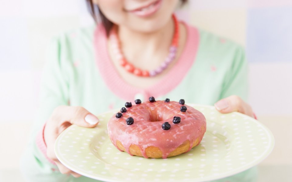 居家少女手捧粉色糖霜蓝莓甜甜圈