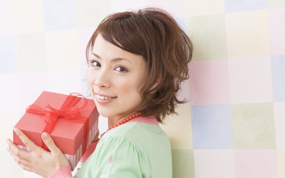 Young Japanese Woman Holding Red Gift Box At Home