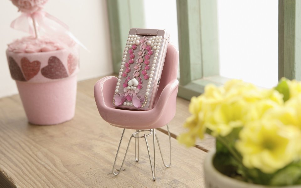 Decorated Vintage Flip Phone On Mini Pink Chair By Window