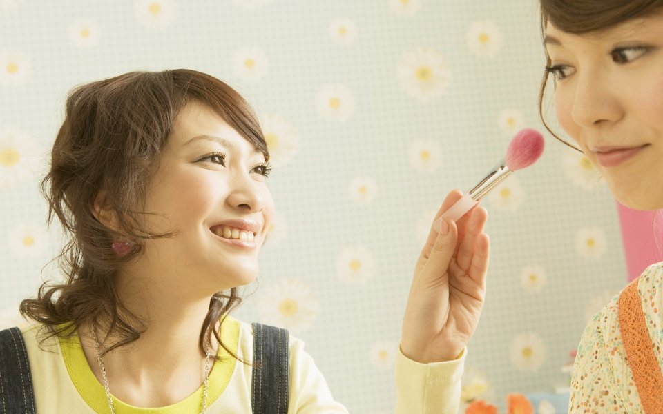Warm Portrait Of Two Young Japanese Girls Doing Makeup At Home