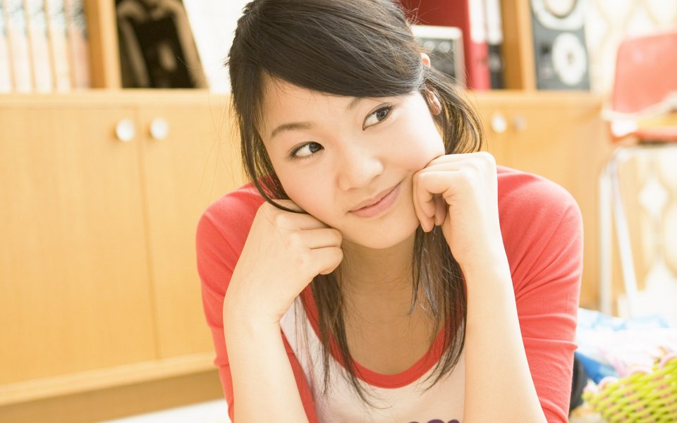 居家室内托腮微笑的清新少女暖光人像摄影