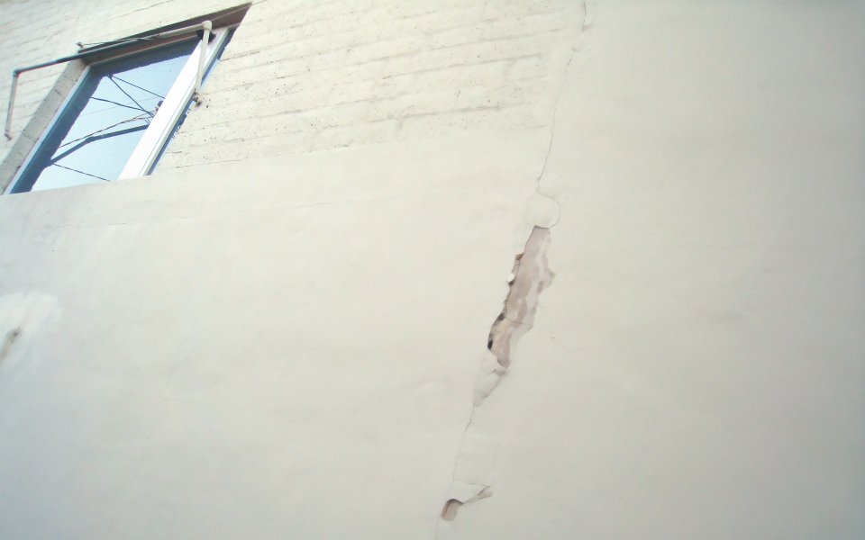 Low Angle Shot Of Old Building Cracked White Exterior Wall