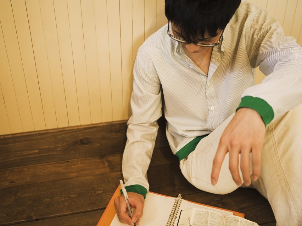 Young Man Writing Notebook On Wooden Floor Home Scene