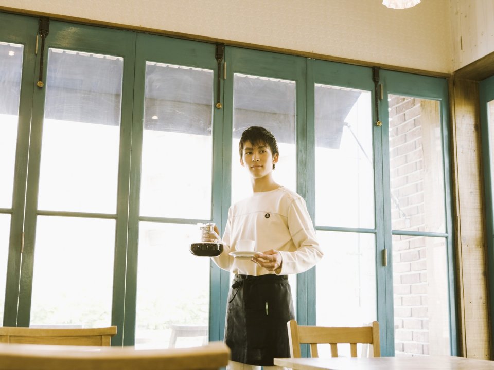 日系咖啡馆男店员端送手冲咖啡暖调写真