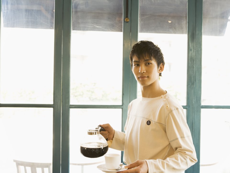 日系咖啡馆窗边端咖啡的年轻男生人像写真