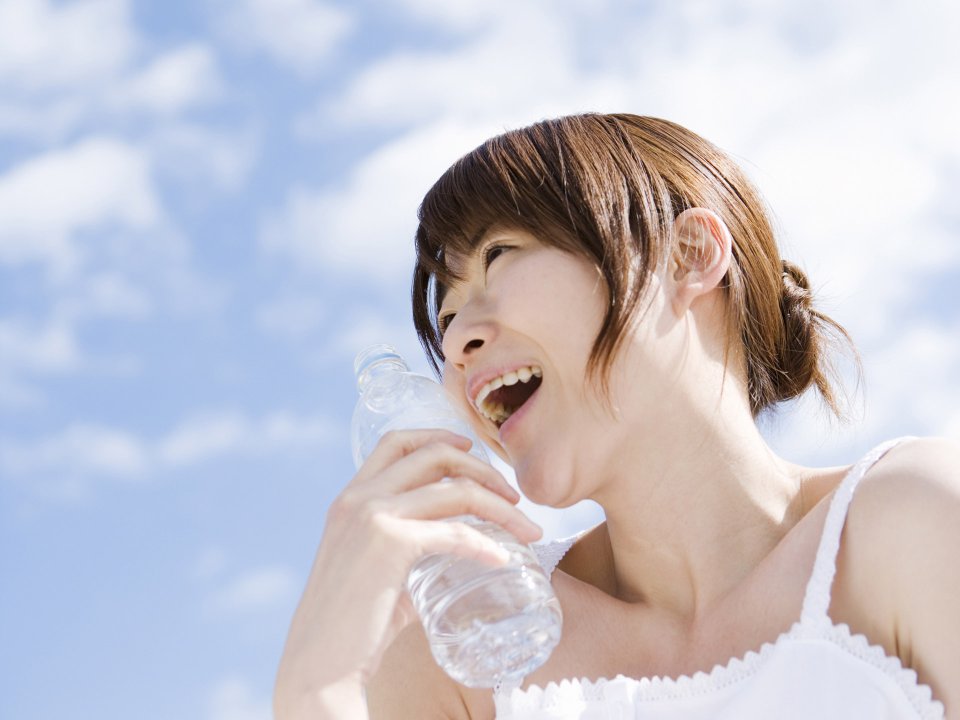 Young Woman Holding Mineral Water Bottle Under Blue Sky
