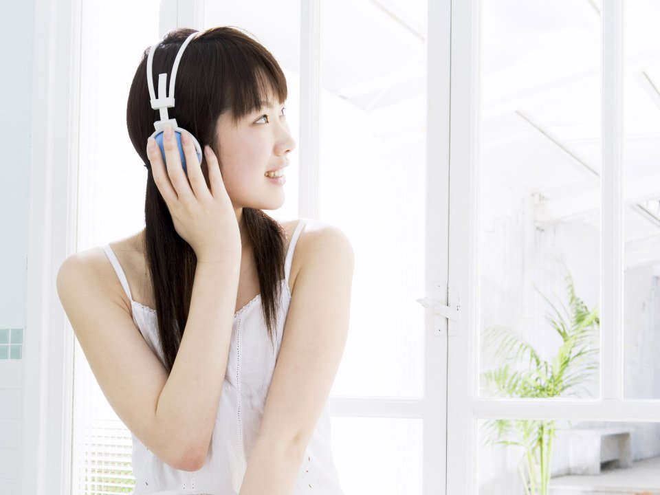 窗边戴耳机听音乐的清新日系少女