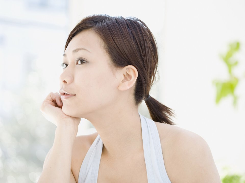 Relaxed Young East Asian Woman Resting Chin On Hand Bright Indoor