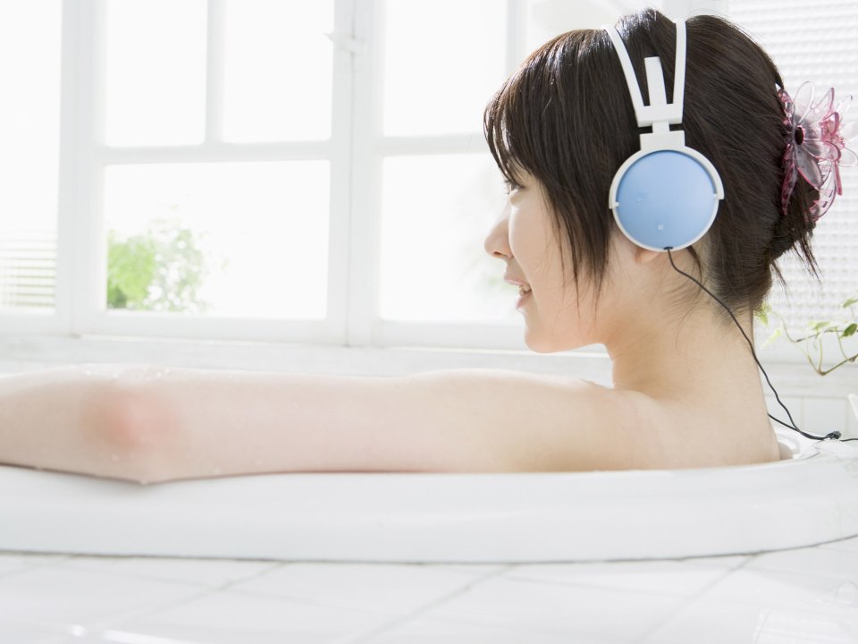 Young Woman Listening To Music In Bathtub Relaxing Leisure Time