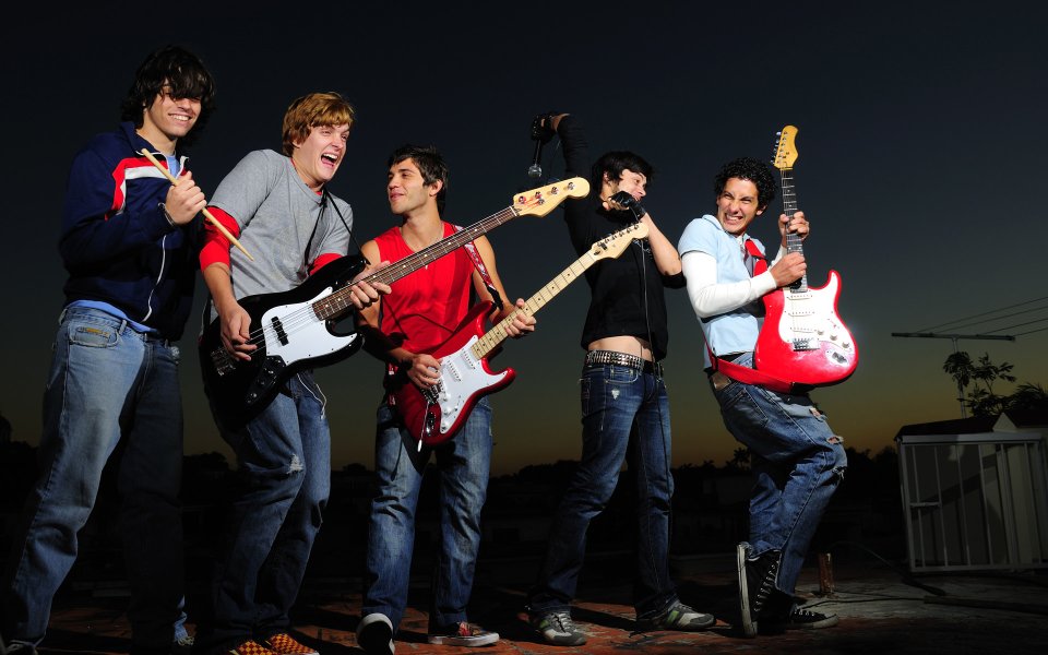 Young Rock Band Performing On Rooftop At Dusk