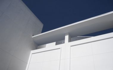 低角度仰拍纯白极简现代建筑与深蓝色晴空