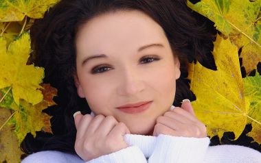 Young Woman Portrait With Autumn Maple Leaves Background