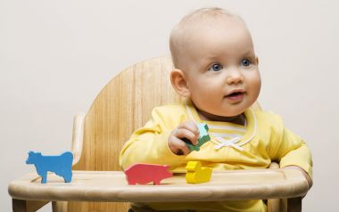 Cute Baby Playing Colorful Wooden Animal Blocks On High Chair