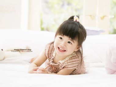 趴在床上微笑的可爱亚洲小女孩 儿童节主题儿童写真
