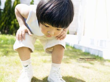 Little Asian Boy Bending On Sunny Lawn Childrens Day Photo