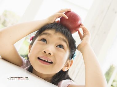 Cute Asian Little Girl With Red Apple On Head Childrens Day Photo