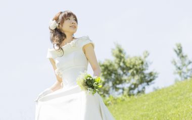 户外花园年轻新娘手持手捧花清新婚纱照
