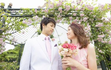 春日户外花园婚纱照 新娘持花束与新郎温柔对视