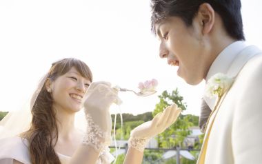 Bride Feeding Groom Wedding Cake At Outdoor Garden Wedding Reception
