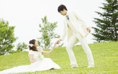 户外草坪日系浪漫婚纱照 新郎牵起坐地的新娘