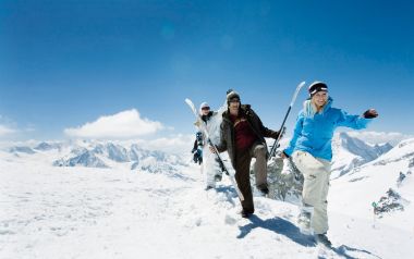 Friends Skiing On Snowy Mountain