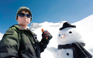 雪山下的小男孩与戴礼帽的雪人