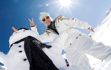 滑雪场里与雪人合影的快乐少女