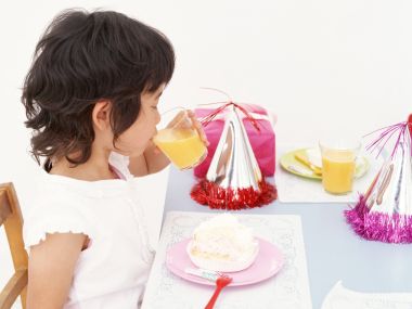 Cute Little Girl Drinking Orange Juice At Birthday Party