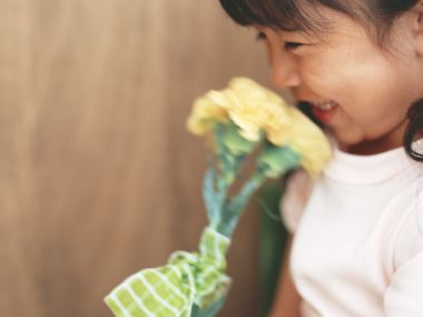 Little Smiling Girl Holding Yellow Carnation Warm Wallpaper
