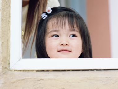 Cute Little Girl With Daisy Hair Clip By Window
