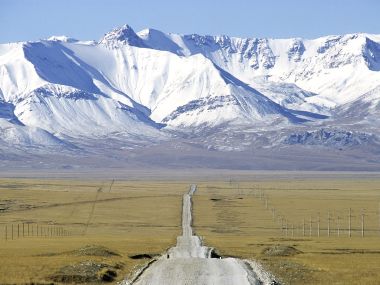吉尔吉斯斯坦雪山下孤独公路原野风光